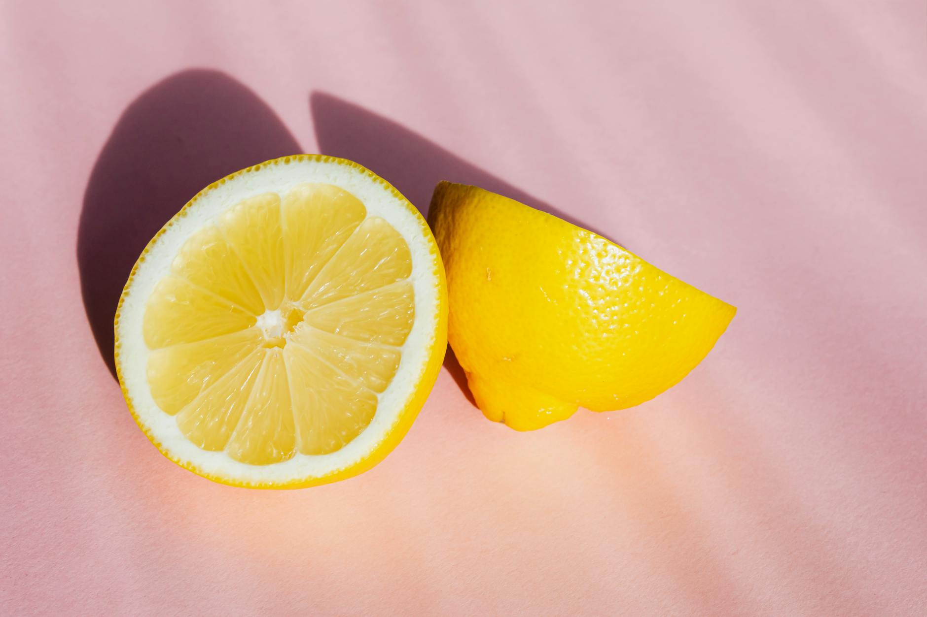 Fresh lemon halves on a pink background symbolizing healing and renewal