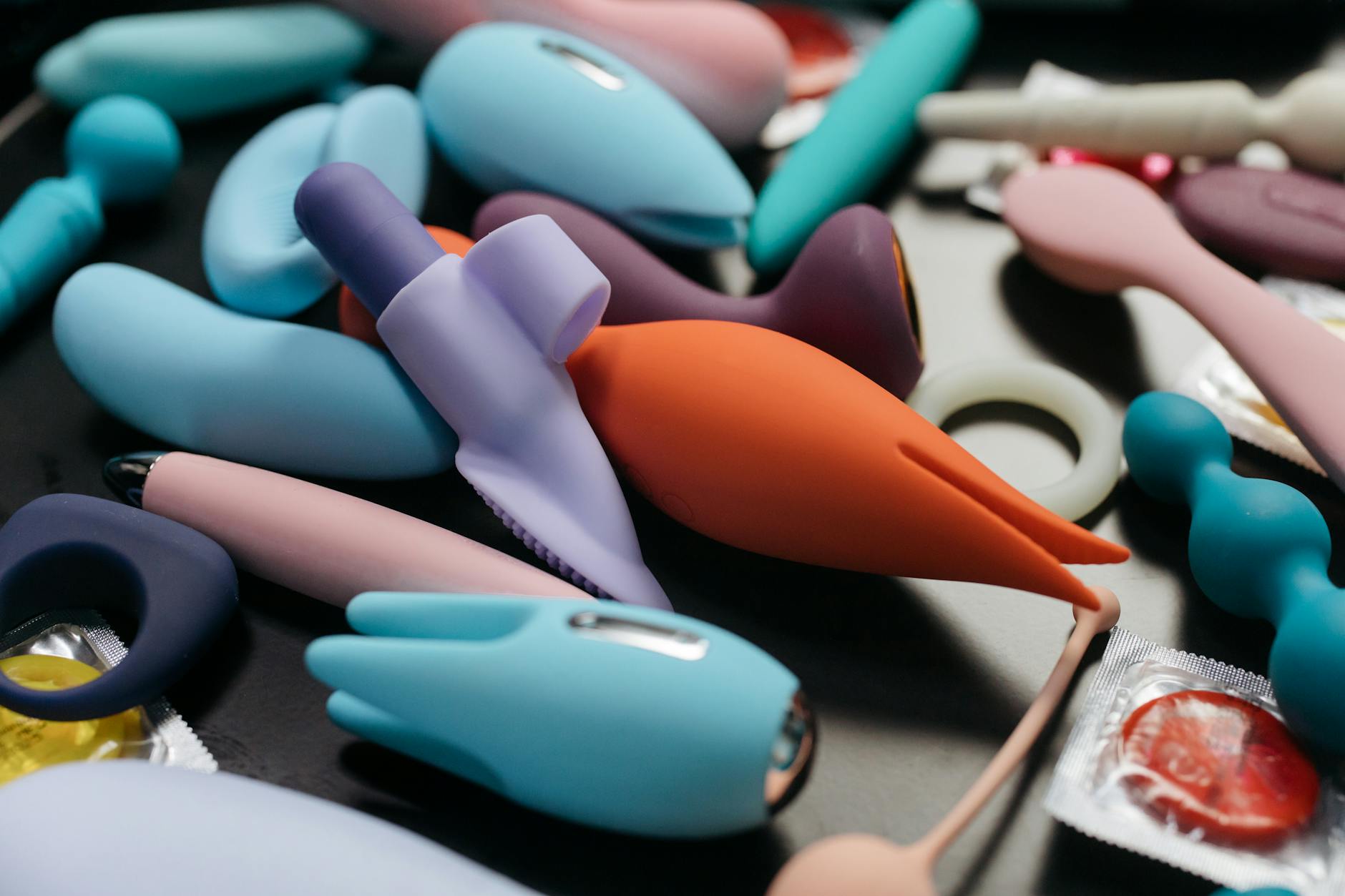 Intimate close-up of hands holding a sleek clitoral vibrator against a purple background