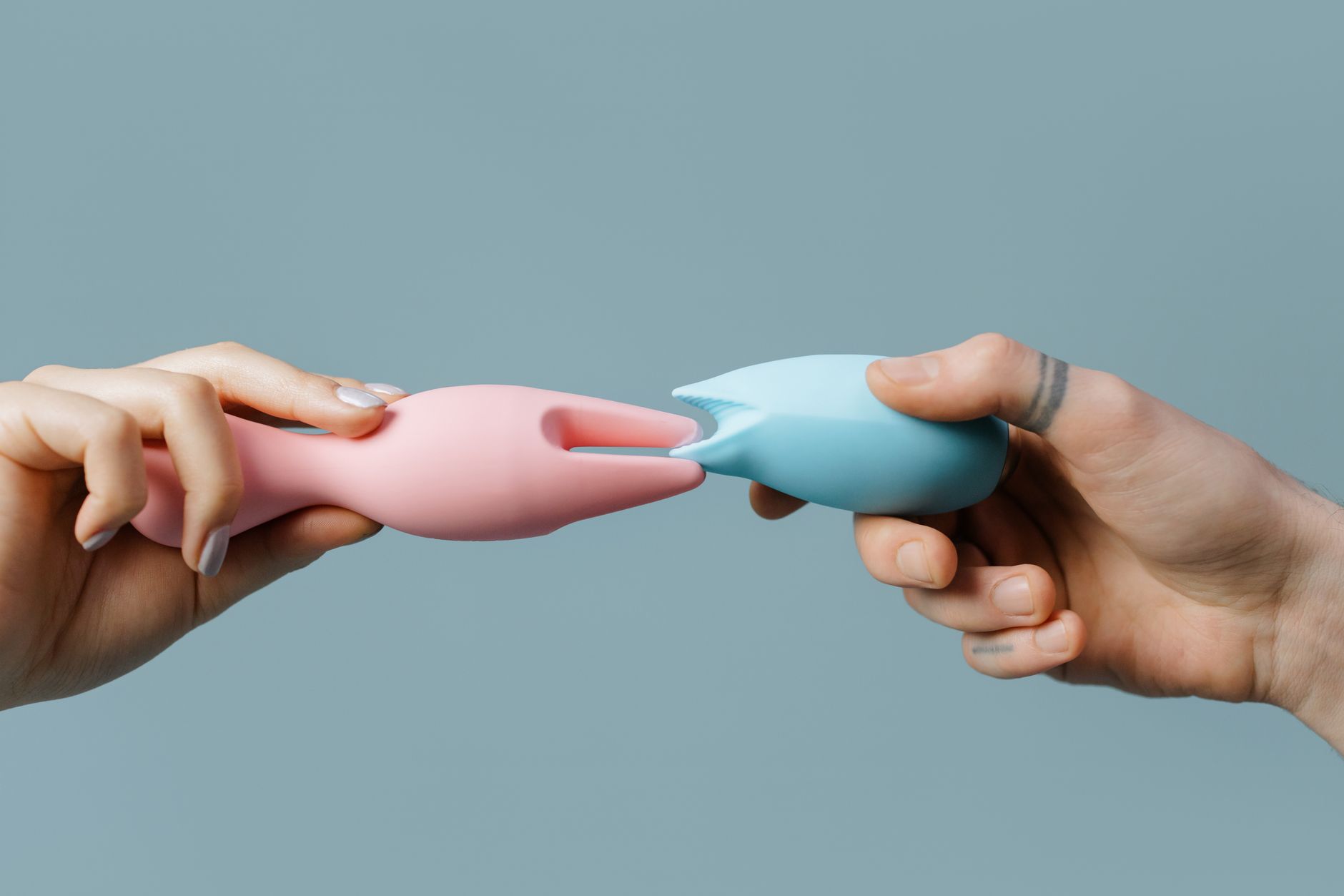 Person holding colorful silicone vibrators with intention