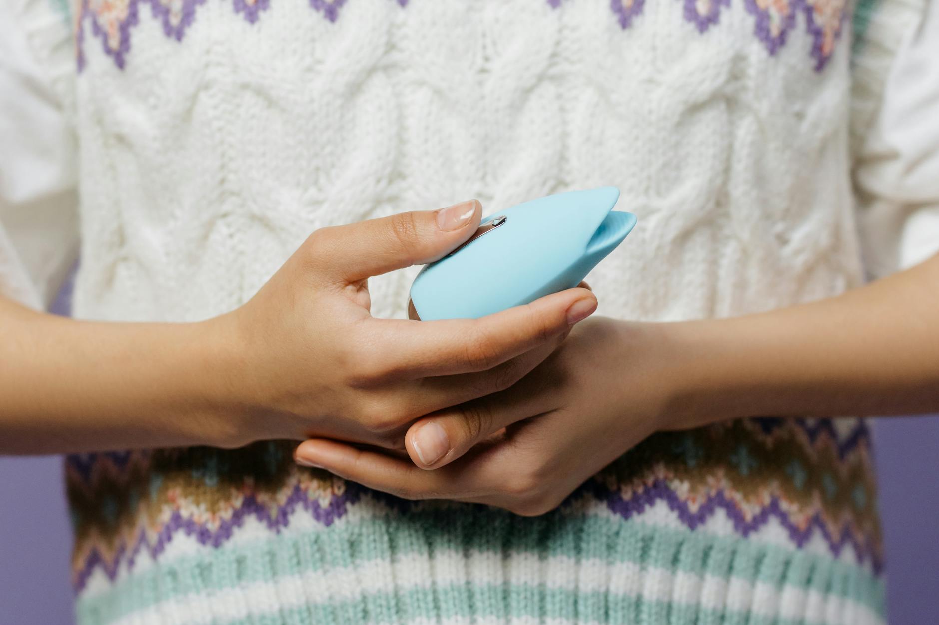 A blue silicone clitoral vibrator held in hand, representing solo pleasure and self-exploration after relationship transition.