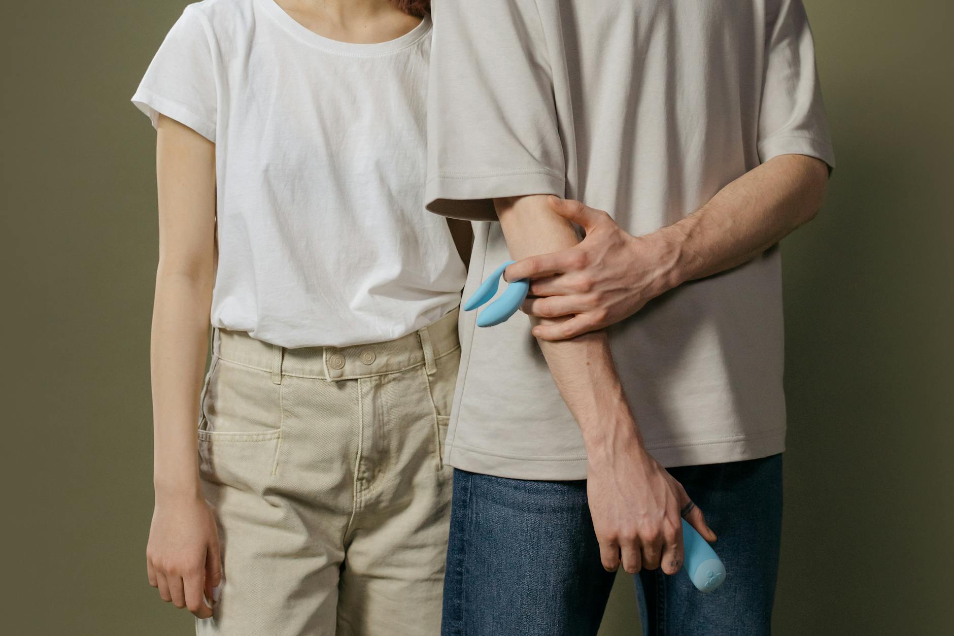 Woman holding blue and pink clitoral vibrators with intention and confidence