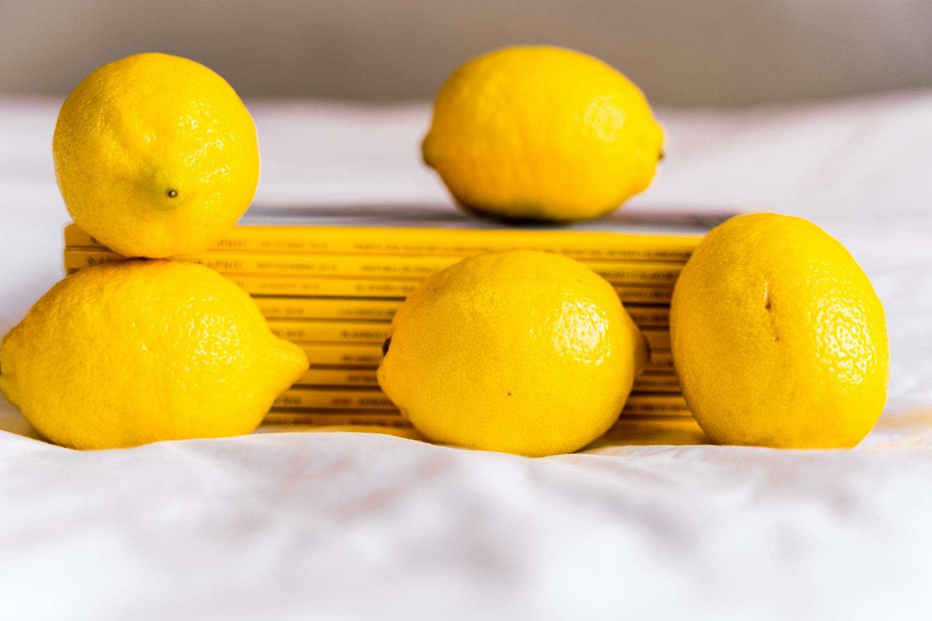 Hand holding a lemon against a vivid yellow background, conveying freshness and intentional exploration